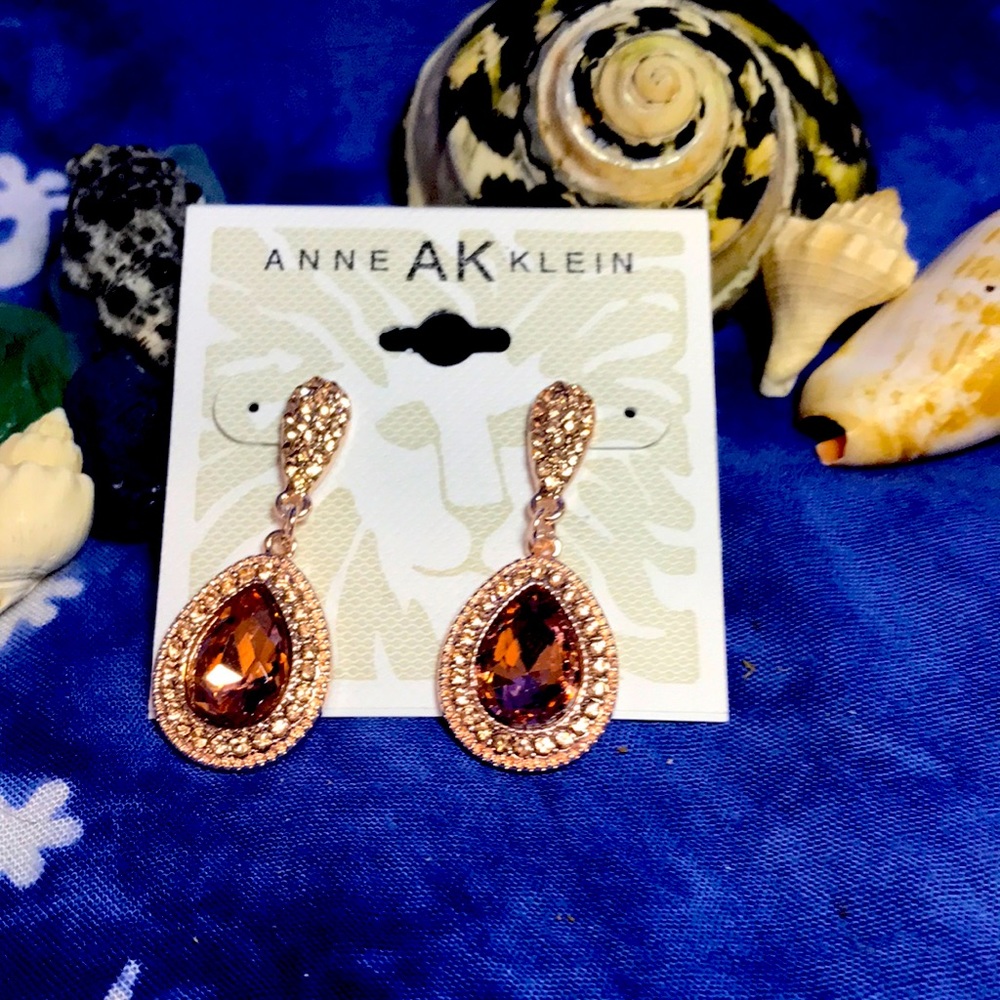 Anne Klein 1 1/2in. Rose tone w/many small stones around large pink stone.